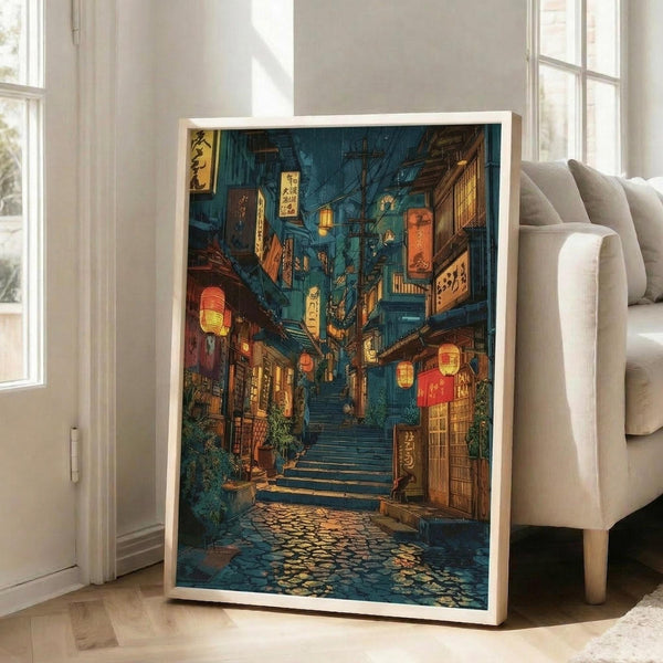 May include: Framed artwork leaning against white wall next to beige sofa in bright room with large windows. The poster shows a moody Japanese street scene at night with glowing red lanterns, wooden stairs leading upward, traditional shop signs with Japanese text, and wet cobblestone ground reflecting warm amber and orange lights. The artwork has rich teal and blue tones contrasted with warm lighting, displayed in a light wood frame.