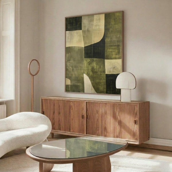 May include: Abstract geometric artwork with green, cream, and black curved shapes displayed above a mid-century modern walnut credenza. Room scene shows white sculptural chair, round glass coffee table, white table lamp, and copper floor mirror on light wooden floors against neutral walls.