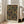 May include: A framed geometric art print with overlapping circles in warm earth tones - rust, olive green, cream, and burgundy stripes against a dark background. The wooden-framed poster displays "bauhaus 1919" text and leans against a white wall next to a beige upholstered sofa in a bright, modern living room with large windows.