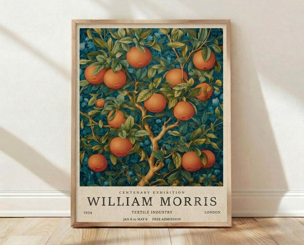 May include: Framed vintage-style botanical poster featuring orange fruit tree with lush green leaves against deep teal background, displayed on wooden floor against white wall with natural lighting and fabric shadows. Light wood frame surrounds artwork with exhibition text below the illustration.