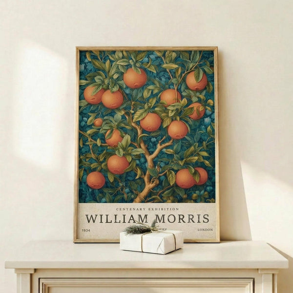 May include: Framed poster featuring orange fruit tree with lush green foliage against deep blue background, displayed on light wood surface with small white wrapped gift. Arts and Crafts style botanical illustration with "William Morris" and "Centenary Exhibition" text at bottom. Natural wood frame complements warm, earthy color palette.