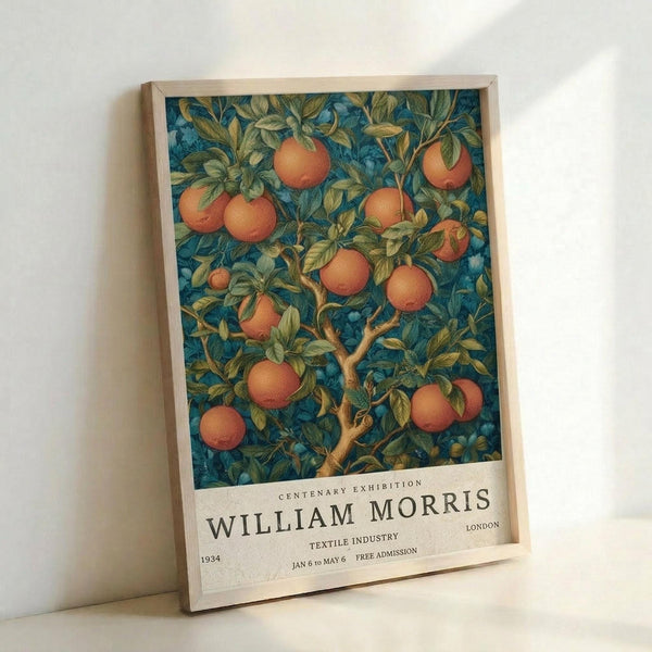 May include: Framed vintage exhibition poster featuring William Morris botanical design with orange fruit tree against deep teal blue background. White text at bottom reads "Centenary Exhibition William Morris London Textile Industry 1934 Jan 6 to May 6 Free Admission." Light wood frame leaning against white wall with soft natural lighting creating gentle shadows.