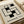May include: Minimalist geometric art print featuring black rectangular shapes arranged in an interlocking pattern on cream background, displayed in thin wooden frame on neutral surface next to rolled paper. Modern Bauhaus-style design with "BAUHAUS EXHIBITION JULY 23, 1923" text in sans-serif font below the abstract composition.