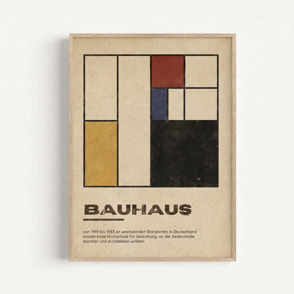 A framed poster with a geometric abstract design featuring colored rectangles in yellow, red, blue, and black arranged in a grid pattern against a cream background. Below the artwork is "BAUHAUS" in bold brown letters followed by German text describing the design school that operated from 1919 to 1933. The poster has a minimalist, modernist aesthetic typical of Bauhaus design principles and is displayed in a light wooden frame against a white wall.