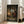 May include: Framed anime poster displayed in bright modern living room next to beige sofa. Shows Japanese samurai character in red robe sitting in traditional wooden interior with tatami mats, scrolls on walls, and warm lantern lighting. Text reads "Samurai Champloo" and "A Hustle to be Free" in white letters. Detailed illustration style with earth tones and atmospheric shading.