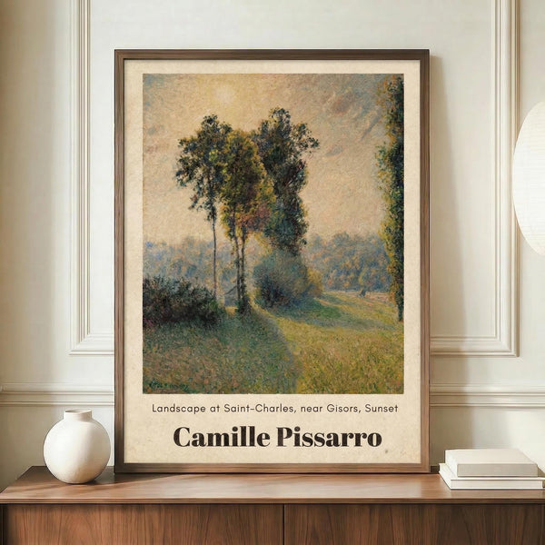 May include: Framed art print of an impressionist landscape painting featuring tall trees along a winding path at sunset, displayed on a wooden sideboard next to a white ceramic vase and stacked books against cream colored paneled walls