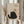 May include: Person holding framed artwork showing black cat silhouette with yellow eyes playing with brown yarn ball, with "Meow" text below. Warm beige textured background, natural wood frame. Soft neutral tones throughout scene with dried pampas grass visible on left side. Cozy minimalist home decor styling.