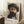 May include: Framed art print of a bearded man in a wide-brimmed hat, painted in impressionist style with visible brushstrokes in warm browns, yellows and purples. The vintage-style poster has a white border with handwritten signature below the portrait. Shown leaning against white paneled wall on a fluffy white rug, beside a wooden side table with white teacup and saucer.
