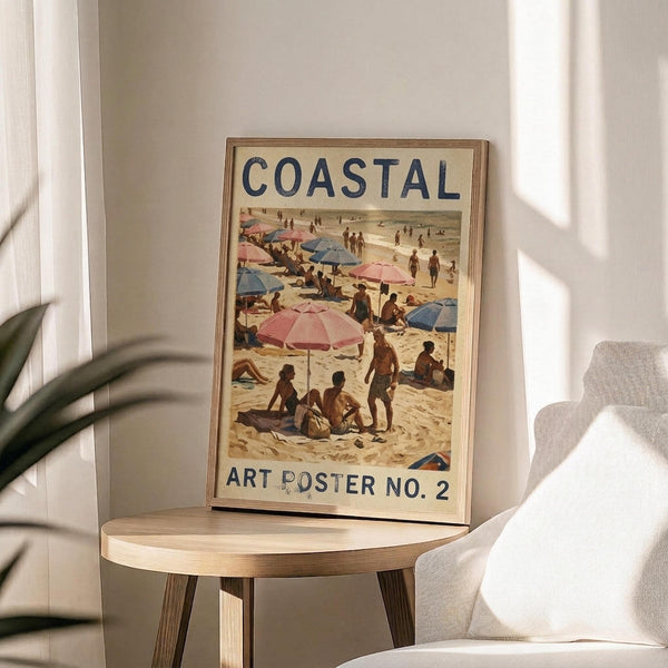 May include: Framed vintage-style beach scene poster with "COASTAL" and "ART POSTER NO. 2" text, showing people with colorful pink and blue umbrellas on sandy beach. Warm sunlight streams across cream walls, wooden round side table, beige upholstered chair, and green plant leaves visible in corner of room.