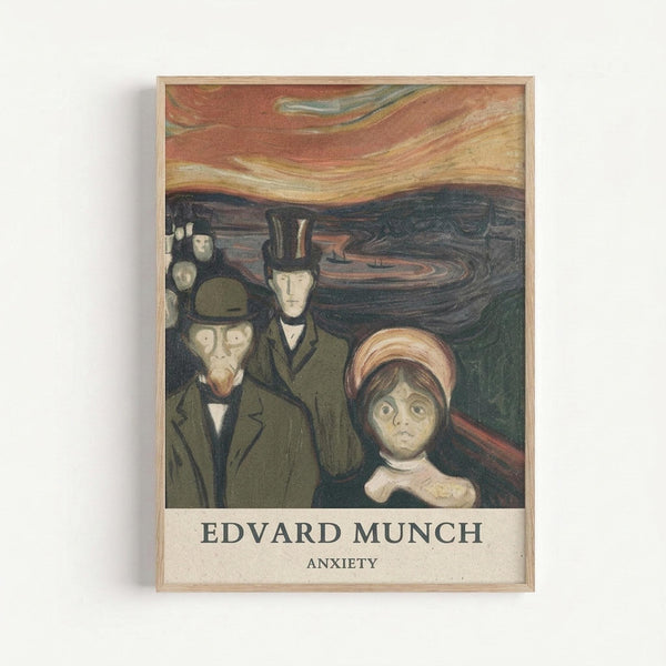 Framed art print showing Edvard Munch's Anxiety painting featuring distorted figures in dark coats and hats with pale, elongated faces against a swirling orange and dark blue sky. A woman in a pink hat stands prominently in the foreground. The artwork has muted earth tones and expressionist style brushwork. Text below reads "EDVARD MUNCH ANXIETY" in black letters on cream background within light wood frame.