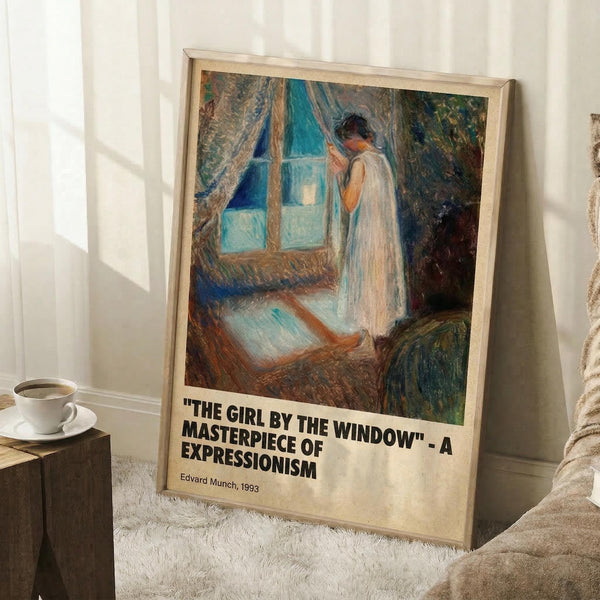 May include: Framed art print leaning against white wall on textured rug, showing Expressionist painting of figure in white dress by window with blue curtains. Warm natural lighting creates shadows on wall. Coffee cup and saucer visible on wooden surface nearby. Light wood frame with descriptive text below artwork.