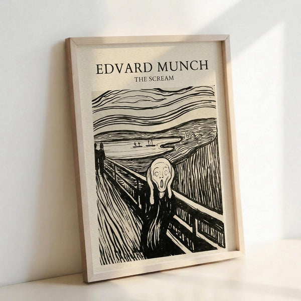 A framed art print of Munch's "The Scream" showing the iconic figure with hands pressed to face in an anguished expression, standing on a wooden bridge against swirling sky lines. The black and white woodcut-style reproduction is mounted in a light wooden frame and leaning against a white wall, creating soft shadows on the surface below.