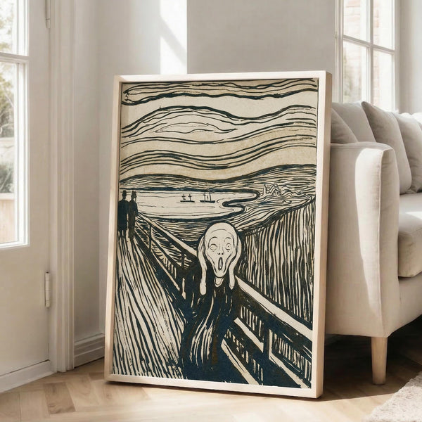 May include: Framed reproduction of Edvard Munch's The Scream artwork leaning against white wall in bright living room with beige sofa. Print shows iconic figure with hands to face on bridge, rendered in black ink with wavy sky lines and swirling patterns. Light wooden frame, approximately 2-3 feet tall, positioned on hardwood floor near large windows.