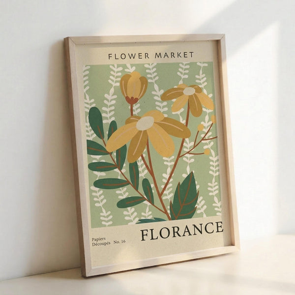 May include: Framed botanical art print with sage green background featuring yellow daisy-like flowers, green foliage, and white leafy branches. Text reads "FLOWER MARKET" at top and "FLORANCE" at bottom with "Papiers Découpés No. 16" in corner. Light wood frame leaning against white wall on light surface with soft natural lighting.