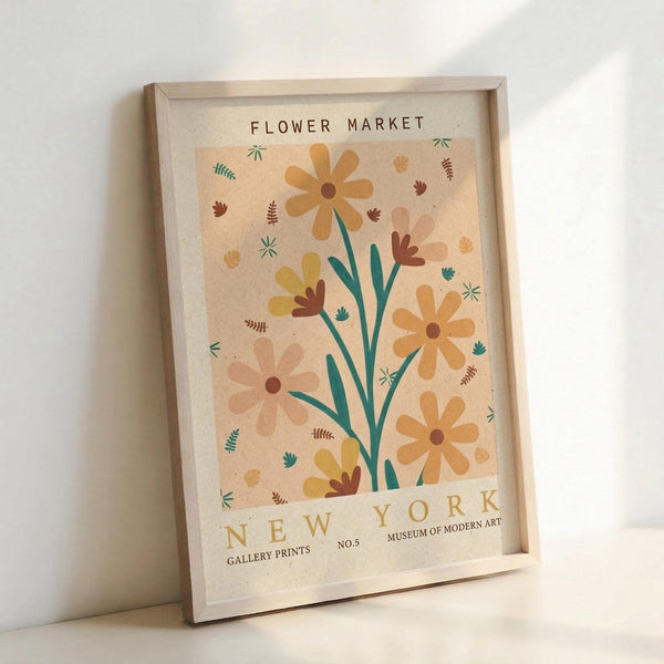 May include: Framed botanical poster print in light wood frame leaning against white wall. Artwork features stylized flowers with orange and yellow blooms, green stems, scattered leaves and small botanical elements on peachy beige background. Text reads "FLOWER MARKET" at top and "NEW YORK GALLERY PRINTS MUSEUM OF MODERN ART NO.5" at bottom in brown lettering. Warm, earthy color palette with mid-century modern illustration style.