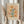 May include: Person in cream ruffled sleeves holding framed botanical poster with stylized flowers in warm oranges, yellows, and teals on beige background. Light wood frame against white curtained window. Dried pampas grass held in other hand. Soft natural lighting creates cozy, minimalist aesthetic.