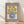 May include: Framed vintage-style poster print featuring six golden yellow flowers with burgundy centers in a blue polka-dotted vase, displayed against a white wall on light wood flooring. The artwork has a purple border with "FLOWER MARKET" text at top and gallery information at bottom, shown in natural lighting with soft shadows.