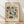 May include: Framed vintage-style botanical poster with colorful folk art flowers in burgundy, orange, and teal against cream background, displayed on light wood floor against white wall with natural shadows