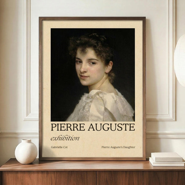 May include: Framed art print featuring a classical portrait of a young woman with curly brown hair wearing a white ruffled dress against a dark background. The poster displays "PIERRE AUGUSTE exhibition" in bold black text below the painting, with smaller text reading "Gabrielle Cot" and "Pierre Auguste's Daughter." The print sits on a wooden sideboard next to a white ceramic vase and books, displayed against cream-colored paneled walls in an elegant interior setting.