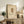 May include: Framed botanical print featuring a detailed fan coral illustration in muted earth tones on cream textured paper, displayed on a rustic wooden sideboard alongside potted fern, stacked books, and ceramic vase in a neutral-toned living room setting with beige upholstered chair.