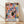 May include: Framed art print leaning against white wall on light wood floor with natural shadows. Abstract colorful composition featuring organic shapes in coral pink, blue, yellow, black, and orange. Modern minimalist interior setting with white baseboard trim. Natural wood frame surrounds poster with "MATISSE" text at bottom in blue letters.
