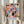 May include: Person holding framed abstract art poster with colorful geometric shapes in pink, blue, orange, yellow, and black cut-out style, with "MATISSE" text below artwork. Light wood frame, neutral beige clothing, dried pampas grass visible, soft natural lighting against cream curtained background.