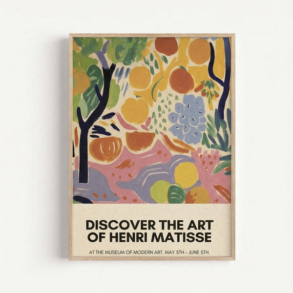 Colorful abstract art poster in light wood frame showing stylized fruits, flowers, and foliage in vibrant yellows, greens, oranges, and purples. Bold black tree branches frame organic shapes and botanical elements painted in loose, expressive brushstrokes. Text at bottom reads "DISCOVER THE ART OF HENRI MATISSE" with museum exhibition details. Poster mounted on white wall with soft shadow.