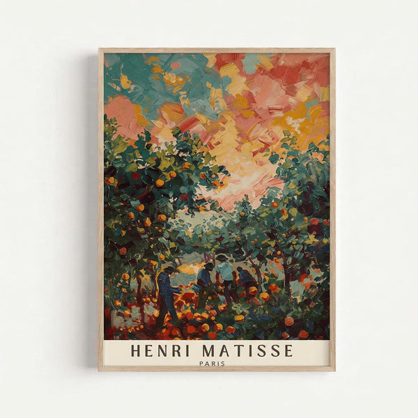 May include: Framed art print in light wood frame mounted on white wall. Colorful impressionist painting showing figures in an orchard with fruit trees under vibrant sky in blues, oranges, and yellows. Bold brushstrokes create textured landscape scene. Text "HENRI MATISSE PARIS" appears at bottom of print in black letters on cream background.