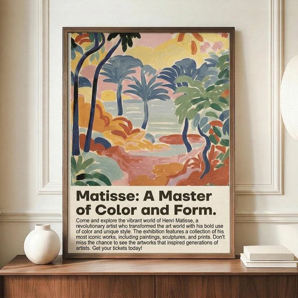 May include: A framed poster featuring a colorful tropical landscape painting with palm trees, foliage, and vibrant blues, greens, yellows, and coral tones in a Fauvist style. The poster includes exhibition text about Matisse below the artwork. The brown wooden frame sits on a wooden surface beside white ceramic vases and books against cream walls with decorative molding.