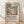 May include: Framed art print featuring a colorful tropical landscape with palm trees, rolling hills, and vibrant pink, yellow, green, and blue brushstrokes in an abstract style. The poster includes exhibition text about Matisse below the artwork. Natural wood frame sits on light wooden floor against white textured wall with soft shadows.