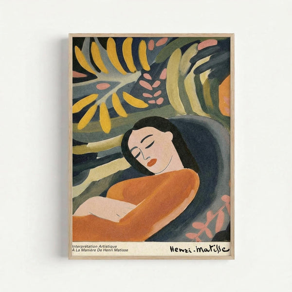 Framed art print showing a woman with long dark hair in an orange dress reclining peacefully with closed eyes, surrounded by stylized tropical foliage in yellow, green, and coral pink. The artwork features bold, simplified forms and vibrant colors in Matisse's distinctive style. Text at bottom reads "Interprétation Artistique À La Manière De Henri Matisse" with artist signature. Light wood frame against white wall.