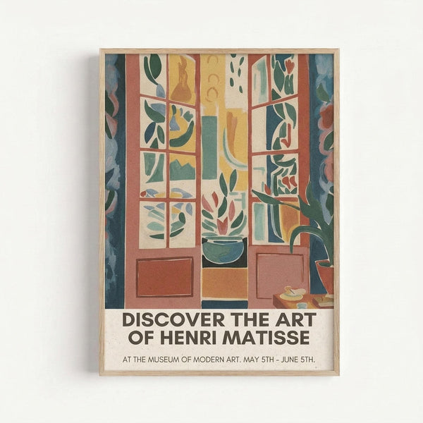 A framed poster showing a stylized interior scene with large windows overlooking greenery. The artwork features warm earth tones - terracotta, yellow, and green - depicting window panes, potted plants, and flowing curtains in a simplified, modern art style. The poster includes text reading "DISCOVER THE ART OF HENRI MATISSE" and museum exhibition details at the bottom. The print is displayed in a light wooden frame against a white wall.