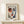 May include: Framed art print featuring an abstract portrait with asymmetrical face in red, blue and white tones, displayed on light wooden console table beside small wrapped gift with twine bow, against neutral beige wall with natural lighting