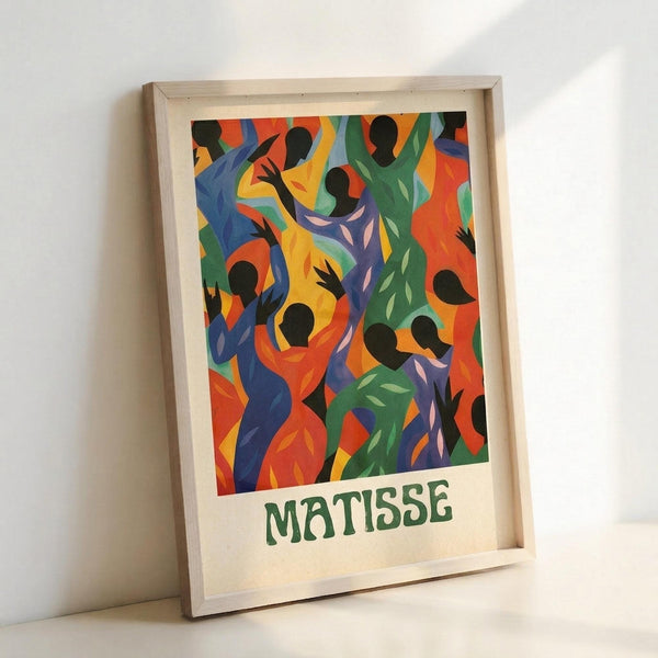 May include: Framed poster print featuring vibrant dancing figures in Henri Matisse's cut-out style with bold colors of blue, orange, green, yellow and purple. Black silhouetted heads and bodies create dynamic movement against bright geometric shapes. Artist name "MATISSE" printed in green text below artwork. Light wood frame with white matting, leaning against white wall corner.