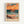 May include: Framed poster print featuring an abstract seascape painting with vibrant orange and pink sunset sky, teal ocean waves, and sandy beach with grass in foreground. The artwork shows expressive brushstrokes and bold colors in an impressionistic style. Text reading "MATISSE" appears at bottom of print. Light wood frame mounted on white wall.