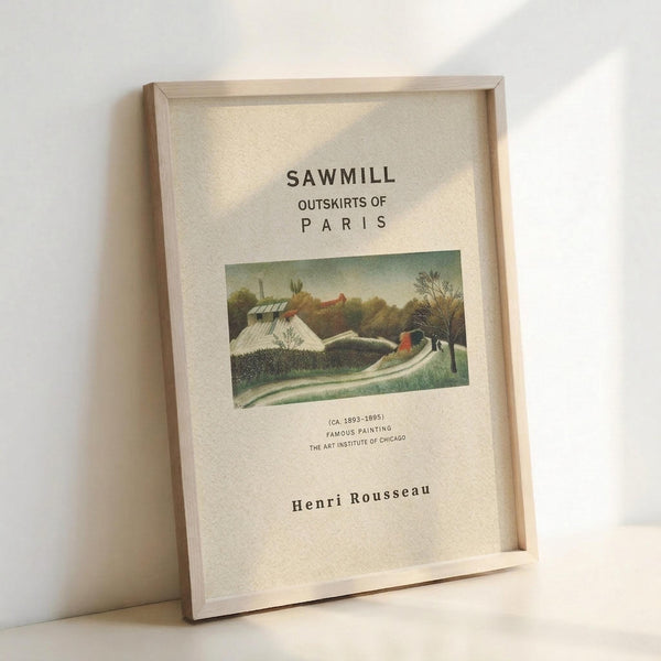 May include: Framed art print featuring Henri Rousseau's pastoral landscape painting with houses, trees, and winding path in muted greens and earth tones. White matted poster displays "SAWMILL OUTSKIRTS OF PARIS" text and museum details. Light wood frame leans against white wall corner, casting soft shadows. Clean minimalist styling showcases vintage exhibition poster format.
