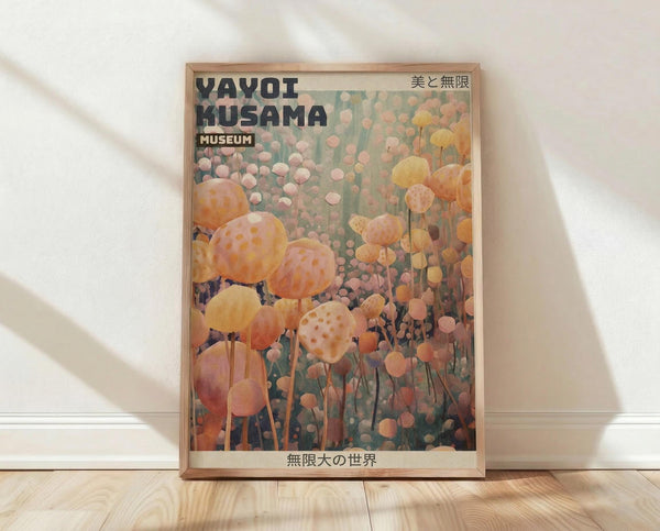 May include: Framed art print leaning against white wall on light wooden floor. Poster features dreamy field of orange, pink and yellow spotted polka dot flowers and spheres in Kusama's signature style. Text reads "Yayoi Kusama Museum" in black letters with Japanese characters. Natural wood frame with soft sunlight casting shadows across white fabric backdrop.