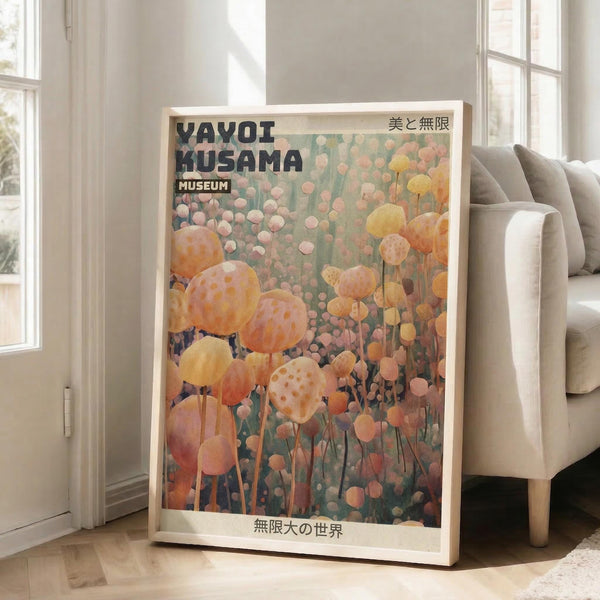 May include: Framed poster featuring abstract orange and pink polka-dotted spherical forms against a muted green background, displayed on wooden floor next to beige sofa in bright sunlit room with white walls and windows. Japanese text visible at top and bottom of artwork in cream-colored frame.