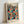 A framed art print featuring Yayoi Kusama's signature polka dot style with overlapping circles in vibrant colors including orange, teal, coral, yellow, and navy against a black background. The poster displays "YAYOI KUSAMA" at the top, "OSAKA 1988" in the upper right, and Japanese text at the bottom. The print is displayed in a light wood frame leaning against a white wall, showing the colorful dotted pattern that creates an infinite, mesmerizing visual effect.