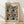 May include: Framed exhibition poster featuring Yayoi Kusama's signature polka dot pattern in overlapping circles of orange, teal, coral, and cream on black background. Wooden frame sits on light wood floor against white wall with soft natural lighting creating gentle shadows.