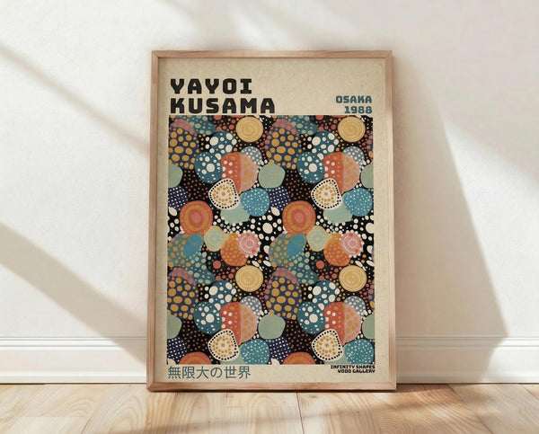 May include: Framed exhibition poster featuring Yayoi Kusama's signature polka dot pattern in overlapping circles of orange, teal, coral, and cream on black background. Wooden frame sits on light wood floor against white wall with soft natural lighting creating gentle shadows.