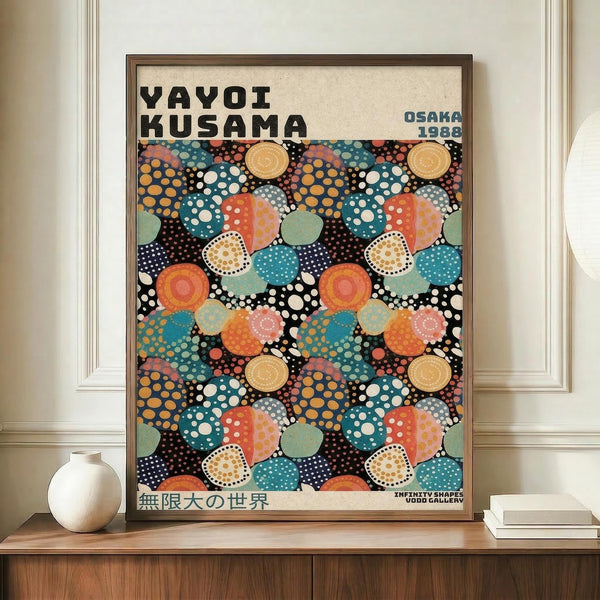 May include: Framed poster with colorful polka dot pattern in vibrant blues, oranges, reds and yellows on black background, displayed on wooden credenza next to white ceramic vase and books. The artwork features overlapping circles with dotted textures in Kusama's signature style, with "YAYOI KUSAMA" and "OSAKA 1988" text at top, Japanese characters at bottom. Cream colored walls and elegant interior setting visible.