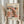 May include: Person holding framed abstract art poster with polka dot patterns in coral, peach, and black colors. Features Japanese text and exhibition details. Light wood frame, neutral background with decorative dried pampas grass visible on left side.