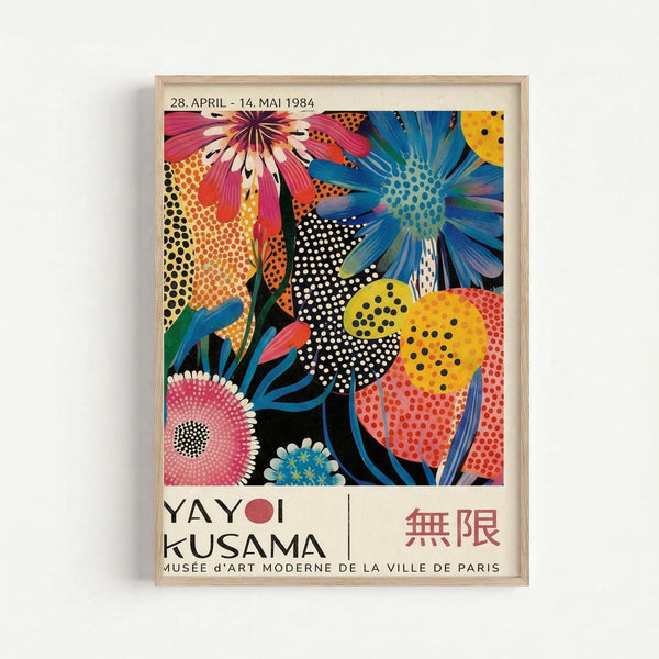A framed vintage exhibition poster featuring vibrant pop art flowers in bold colors including pink, blue, yellow, and orange. The stylized blooms have polka dot patterns and geometric designs against a black background. Text shows dates "28. APRIL - 14. MAI 1984" at top, with "YAYOI KUSAMA" and "MUSÉE D'ART MODERNE DE LA VILLE DE PARIS" below the artwork, plus Japanese characters. The poster is displayed in a light wooden frame against a white wall.