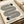 May include: Framed Bauhaus-style poster with black concentric oval lines forming geometric pattern on cream background, featuring two half-circles with radiating lines, displayed on neutral beige surface with rolled paper tube nearby. Modern minimalist design with "bauhaus 1919" text at bottom.