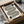 May include: Black and white geometric poster with curved concentric lines forming abstract shapes, displayed in black frame inside cardboard shipping box with protective wrapping. Minimalist Bauhaus-style design on cream background with "1919 bauhaus" text and small circular elements in corners.