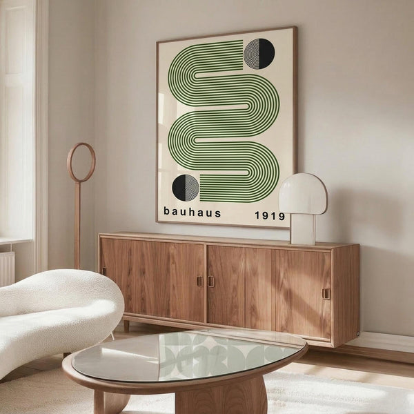 May include: Modern living room with wooden sideboard displaying framed geometric poster featuring flowing green striped wave design with black circular elements on cream background. Room styled with contemporary white curved chair, glass coffee table, and minimalist decor in neutral tones.