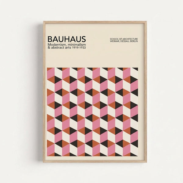 Framed poster with geometric cube pattern in pink, orange, black and cream colors creating a 3D optical illusion effect. The print features "BAUHAUS" text at top with "Modernism, minimalism & abstract arts 1919-1933" and "SCHOOL OF ARCHITECTURE WEIMAR, DESSAU, BERLIN" below. Light wood frame mounted on white wall background.