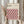 May include: Hands holding a framed geometric poster featuring a repeating cube pattern in pink, coral, black, and cream colors. The frame is light wood against a neutral background with dried pampas grass visible to the left. The poster displays "BAUHAUS" text at the top with dates 1919-1933 and references to modernism, minimalism and abstract arts.