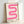 May include: Framed poster with pink gradient ribbon design creating wavy S-shaped curves on cream background, displayed in light wood frame leaning against white wall. The ribbon has multiple pink tones from light to bright magenta with smooth flowing lines. Black text reads "bauhaus 1919" at bottom of print.